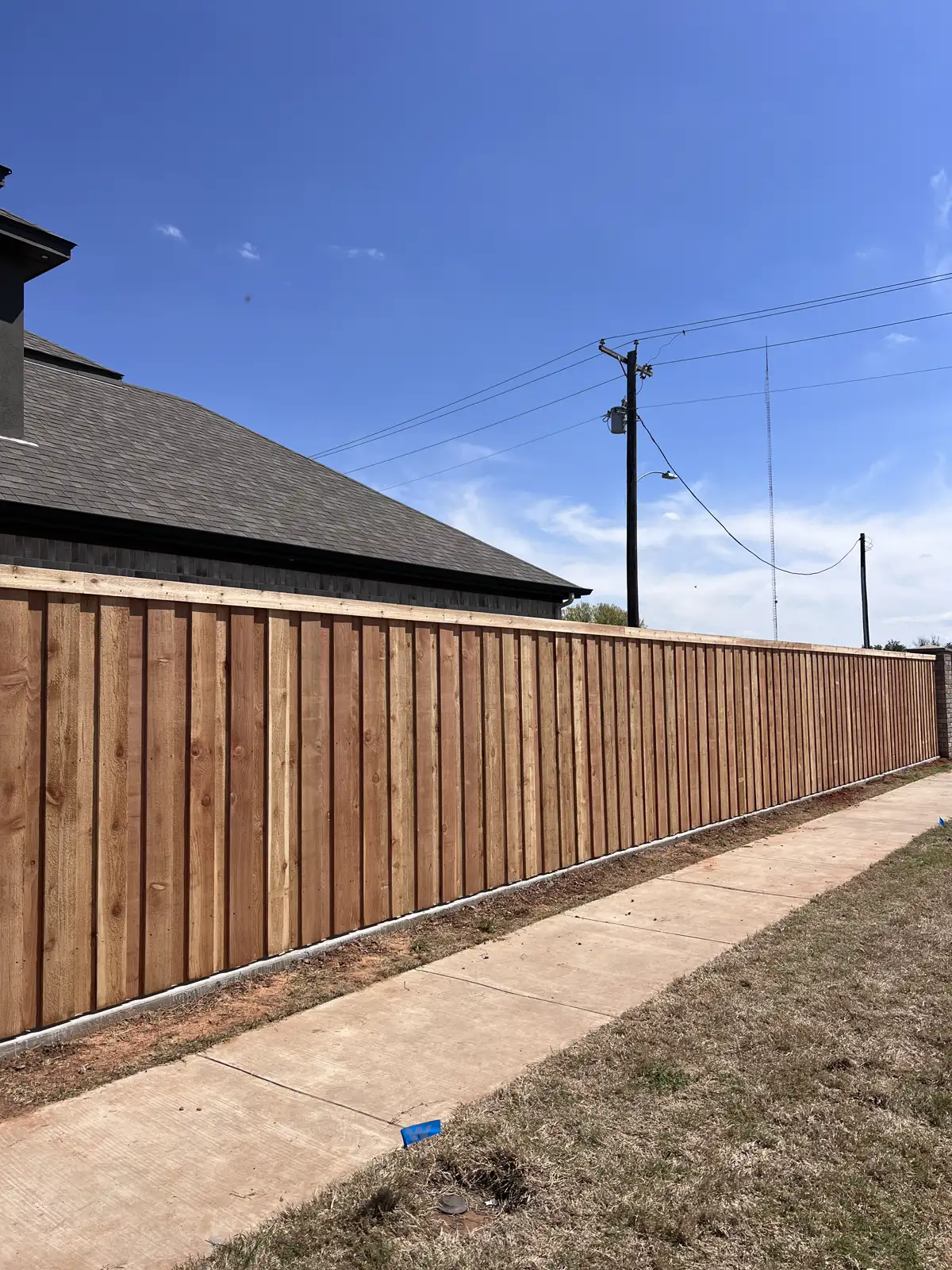 Board-on-board cedar privacy fence with top cap along a sidewalk in Wichita Falls
