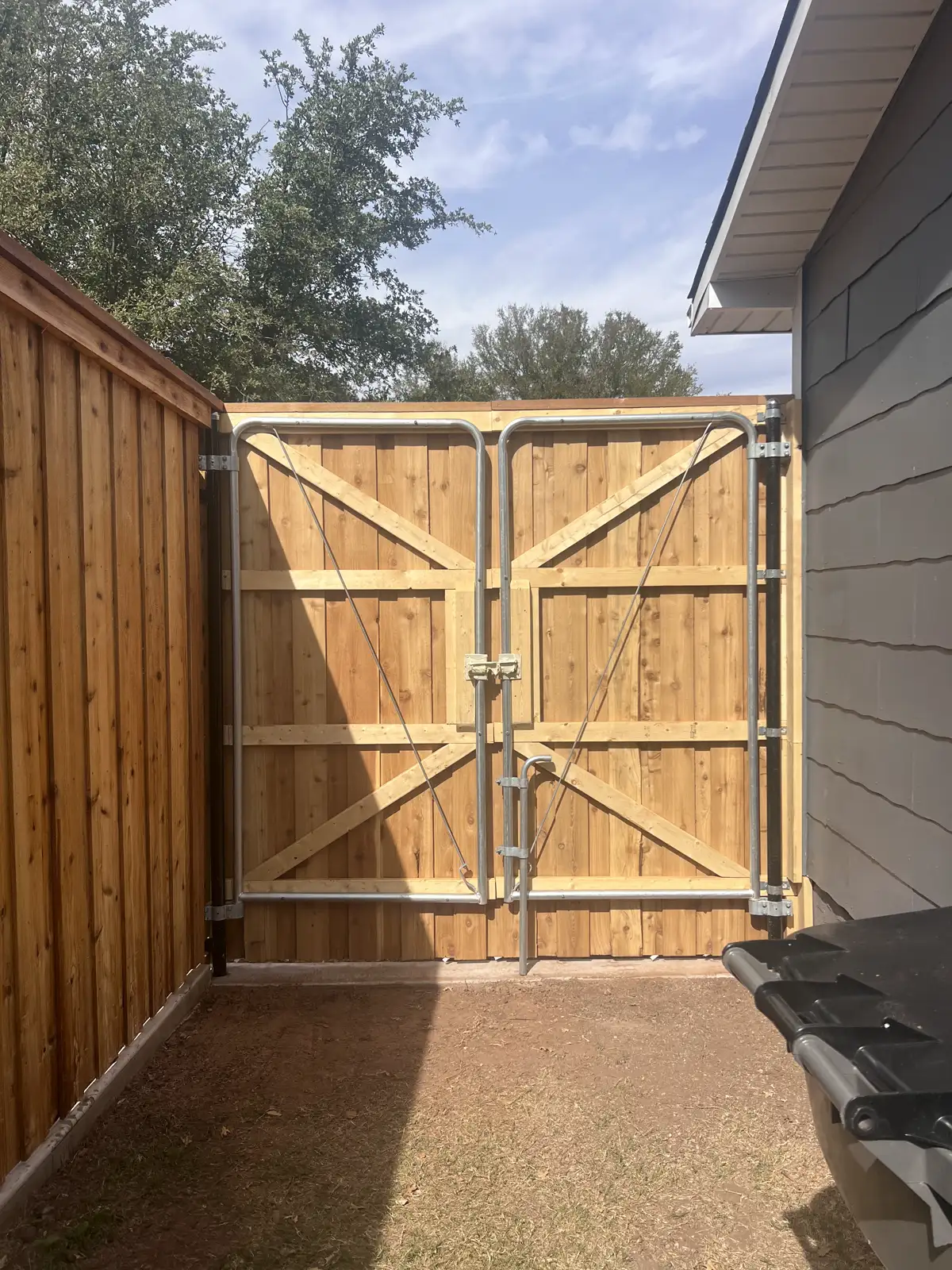 Custom cedar double drive gate built by Red River Roofing & Construction in Wichita Falls, TX