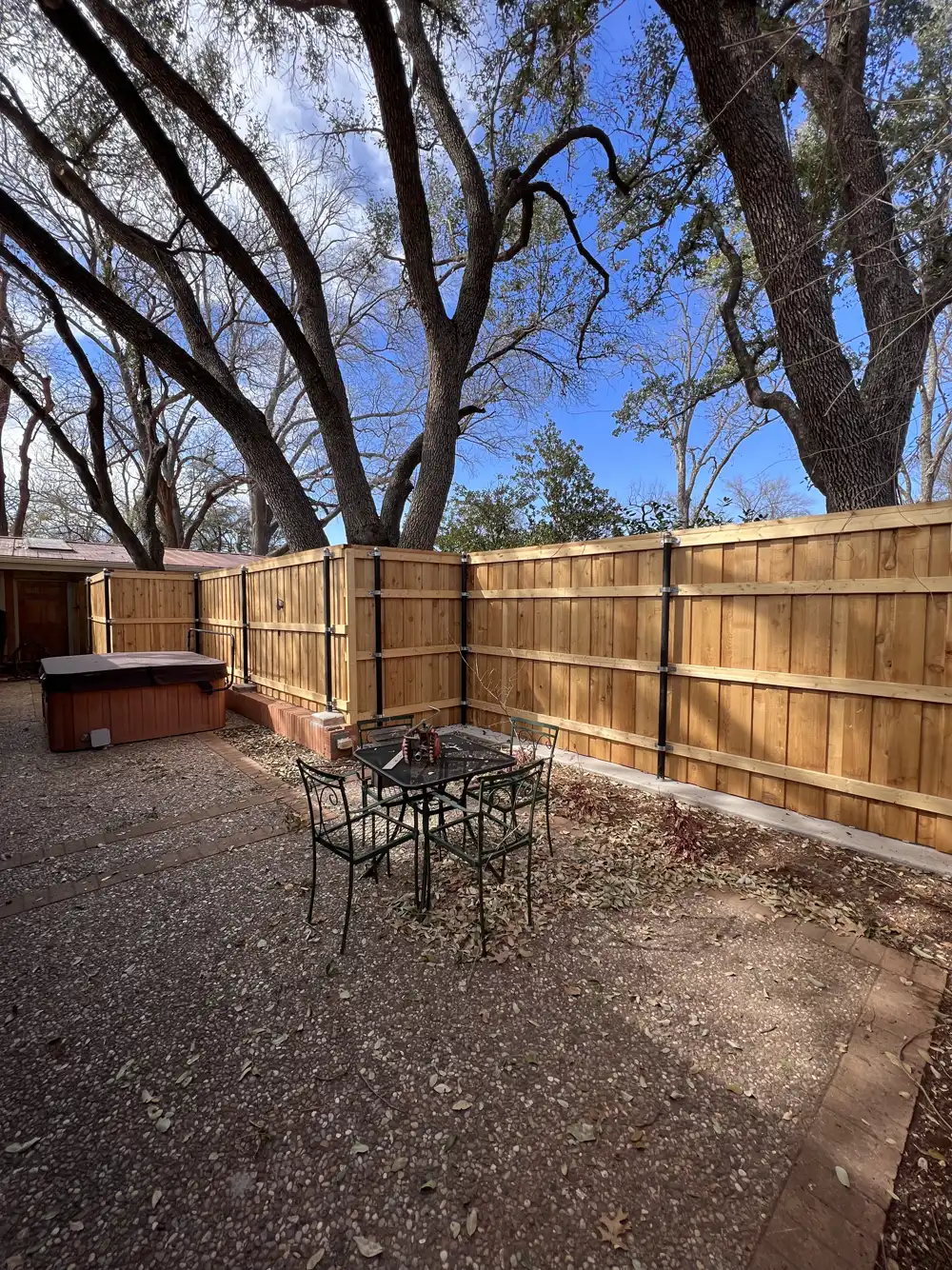 Cedar privacy fence on black steel posts around a backyard patio in Wichita Falls