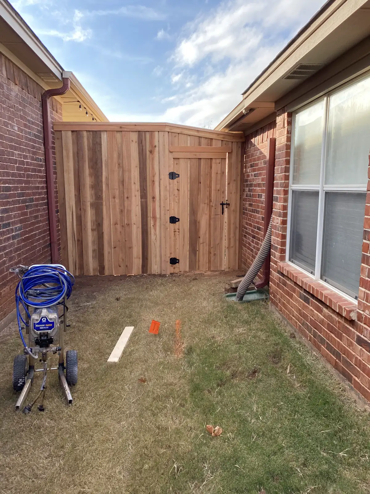 Cedar privacy side gate installed between brick walls of a Wichita Falls home