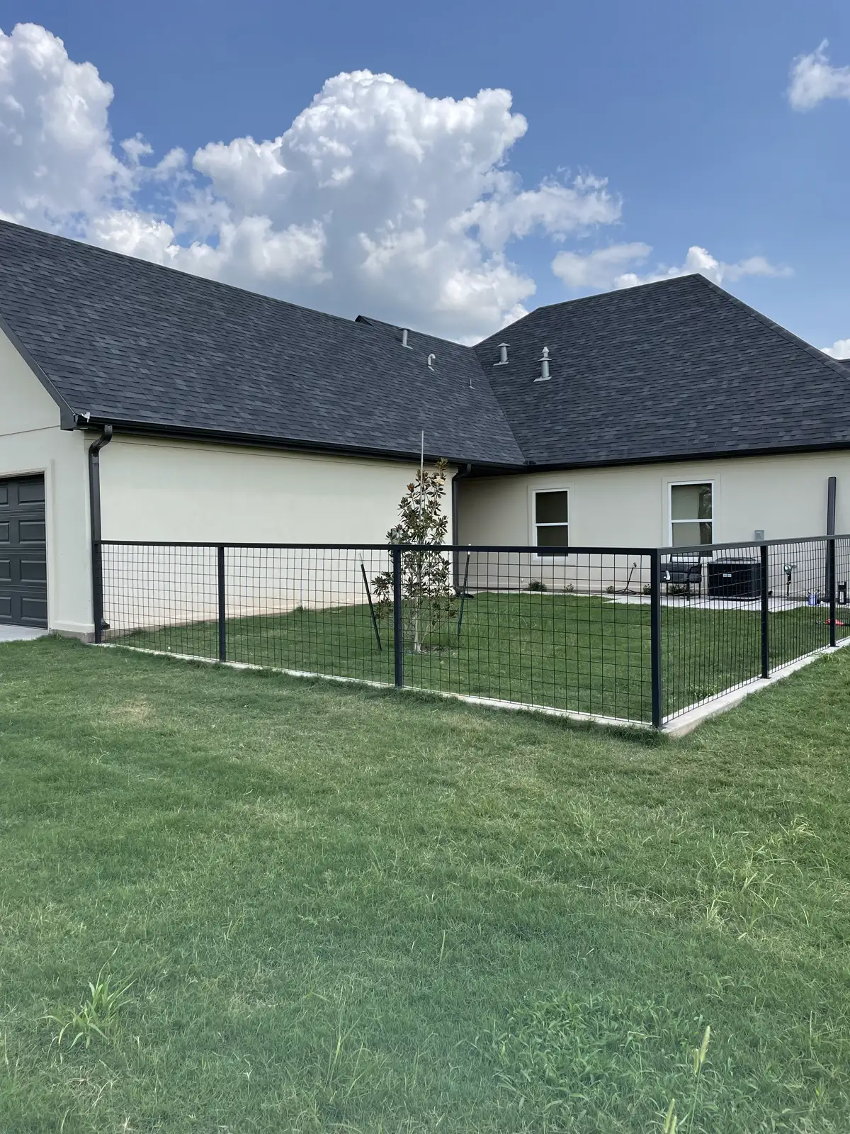 Black-framed hog wire fence around the yard of a new home near Wichita Falls, TX
