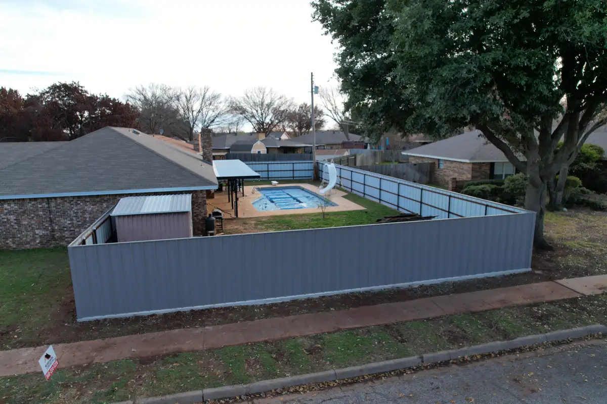Aerial view of a metal panel privacy fence enclosing a backyard pool in Wichita Falls, TX